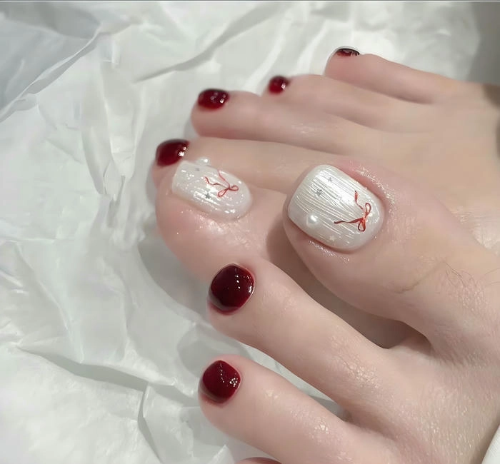 mẫu nail chân màu đỏ nơ nhẹ nhàng
