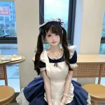 Gái xinh mặc đồ hầu gái tạo dáng bên bàn gỗ cổ điển